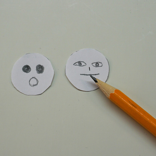 Auf die Papierkreise werden Augen und Mund gemalt