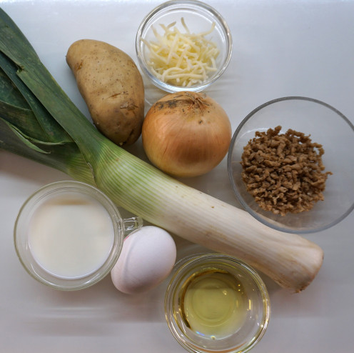 1 Stange Lauch, 1 Zwiebel, 1 Ei, 1 Kartoffeln, Schälchen mit Öl, Schälchen mit veganem Hack, Schälchen mit Milch