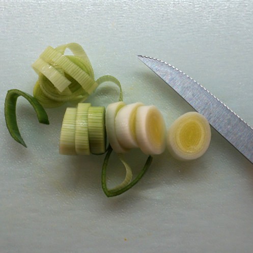 Lauchscheiben auf einem Brettchen und ein Messer